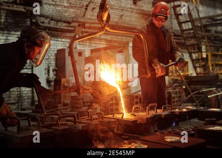 The welder works in the factory shop two steel workers melting metal Stock Photo