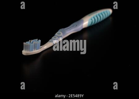 Selective focus on toothbrush isolated on black background. Stock Photo