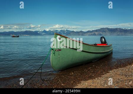 Green Inuit canoe with an engine by the beach in Pond Inlet Stock Photo