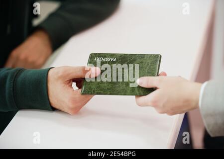Close-up of man giving his passport for registration Stock Photo