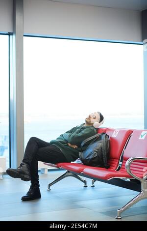 Man sleeping on chair in waiting room of the airport terminal Stock Photo