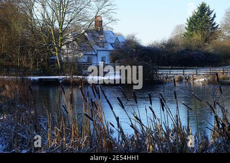 Cottage near a frozen Willian Pond in the January snow