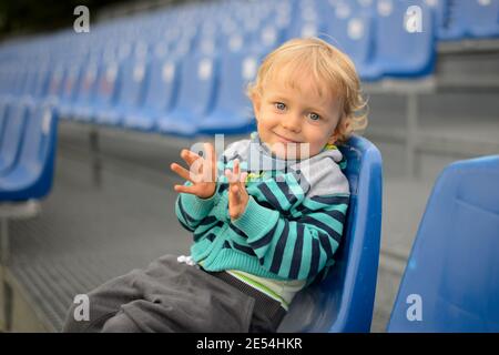 The little boy sits on a tribune Stock Photo