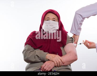 Covid-19 vaccine is given to elderly Turkish old women. Stock Photo
