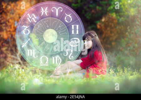 Astrology in summer with beautiful girl and Zodiac wheel. Stock Photo