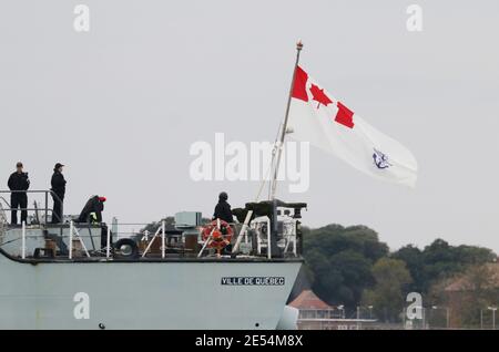 The ensign of the Royal Canadian Navy flies from the stern of the frigate HMCS VILLE DE QUEBEC (FFH332) as the ship leaves harbour Stock Photo