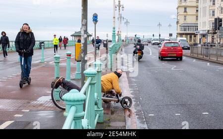 Brighton UK 26th January 2021 - This chap has a novel form of transport along Brighton seafront as the coronavirus COVID-19 restrictions continue in England and the UK : Credit Simon Dack / Alamy Live News Stock Photo