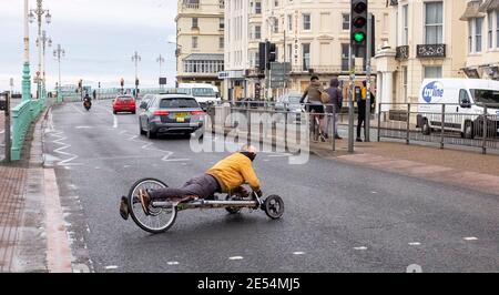 Brighton UK 26th January 2021 - This chap has a novel form of transport along Brighton seafront as the coronavirus COVID-19 restrictions continue in England and the UK : Credit Simon Dack / Alamy Live News Stock Photo