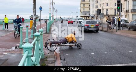 Brighton UK 26th January 2021 - This chap has a novel form of transport along Brighton seafront as the coronavirus COVID-19 restrictions continue in England and the UK : Credit Simon Dack / Alamy Live News Stock Photo