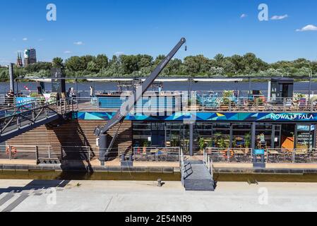 Almost empty boat bar on the Vistula River bank during COVI19 pandemic  in Warsaw city, Poland, National Stadium on background Stock Photo