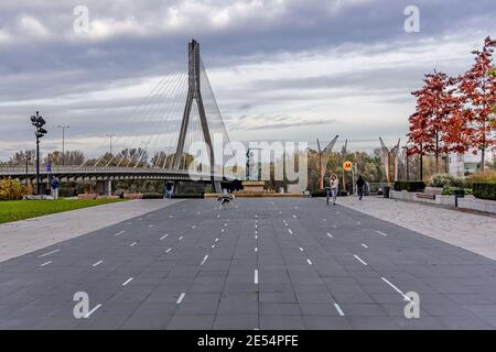 Mermaid statue on Vistulan Boulevards and Swietokrzyski Bridge over Vistula River bank in Warsaw city, Poland Stock Photo