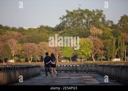 A couple walks on the Kandawgyi Lake wooden bridge, Yangon, Myanmar. Stock Photo