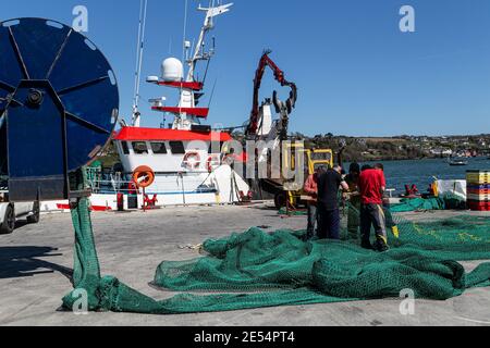 Kinsale, County Cork, Ireland. 19th April, 2016. Fishermen repairing a fishing net on Kinsale harbor pier, County Cork, Ireland. Stock Photo