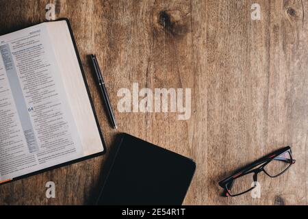Premium Photo  Holy bible, notebook, glasses and pen on a desk