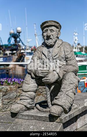 Kinsale, County Cork, Ireland. 19th April, 2016. Statue of a fisherman sculpted by Graham Brett on Kinsale harbor pier, County Cork, Ireland. Stock Photo