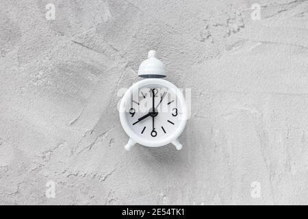 Small vintage alarm clock with bell on gray background Stock Photo