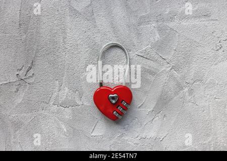 Red padlock or love lock on gray background, heart shaped Stock Photo
