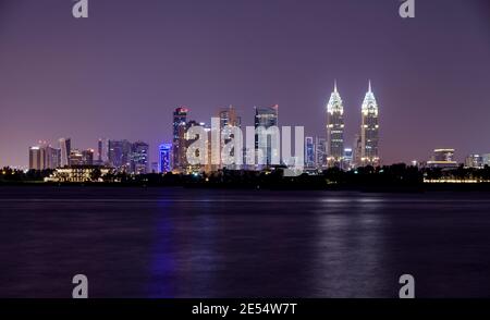 A panaromic view of the illuminated Dubai skyline with the majestic skyscrappers, business centres captured at the Palm jumeirah east, Dubai Stock Photo