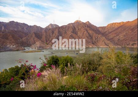 BOATS, KAYAKS IN THE RAFIS WATER DAM  AT SUNSET TIME IN THE MOUNTAINS ENCLAVE REGION OF KHOR FAKKAN, SHARJAH UNITED ARAB EMIRATES Stock Photo