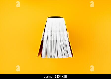 top view of big book with yellow cover on orange background Stock Photo