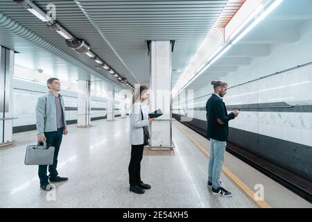 various subway passengers waiting for the arrival of the train . Stock Photo