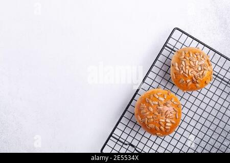 Homemade tasty buns with seeds on cooling rack. Top view. Copy space - Image Stock Photo