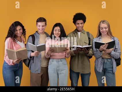 Happy young university students studying with books in library Stock Photo