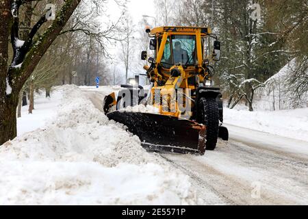 Yellow motor grader Vammas removing snow from street after heavy snowfall in Salo, Finland. January 22, 2021. Stock Photo