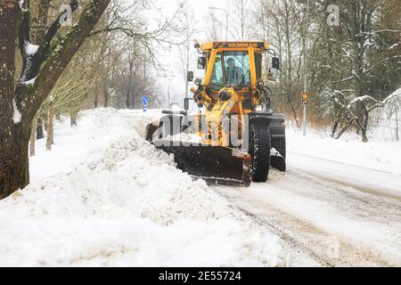 Yellow motor grader Vammas removing snow from street after heavy snowfall in Salo, Finland. January 22, 2021. Stock Photo