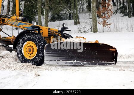 Yellow motor grader Vammas removing snow from street after heavy snowfall. Detail. Salo, Finland. January 22, 2021. Stock Photo