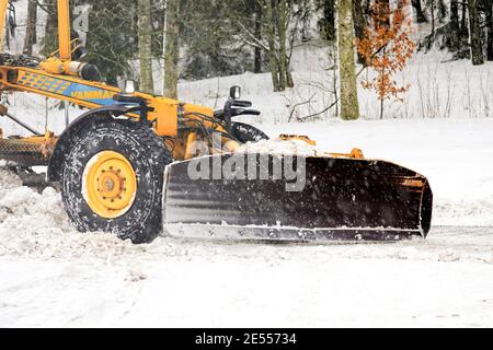 Yellow motor grader Vammas removing snow from street in light snowfall. Detail. Salo, Finland. January 22, 2021. Stock Photo