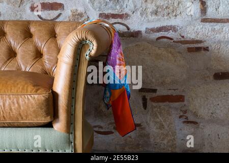 Interior design leather sofa with scarf, wall in brick and stone Stock Photo