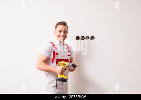 The young electrician happily does his job Stock Photo