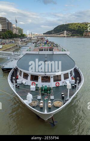 Budapest, Hungary - July 17, 2012: A huge ship, type ferry, docked on the wide Danube river, passing through Budapest, with the Elisabeth Bridge in th Stock Photo