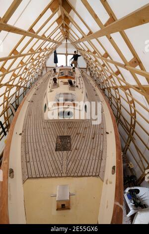 Baba 35  yacht Black Sheep'being in stages of a major refit by Tim Newson owner and shipwright in his purpose -built boat tent at Dell Quay Chichester Stock Photo