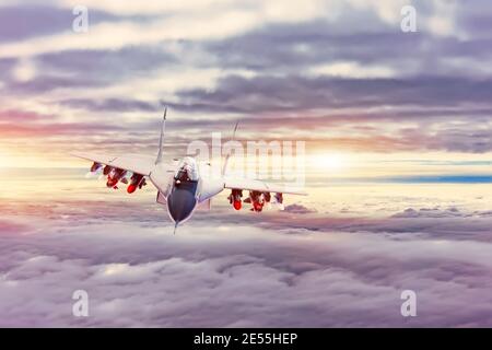 Invisible fighter plane flying in the clouds at sunset Stock Photo