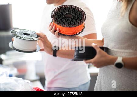 3D Printer Plastic filament for 3D printer and printed products in the hands of a young man Stock Photo