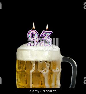 number 93 candle in beer mug for birthday celebration isolated on black Stock Photo