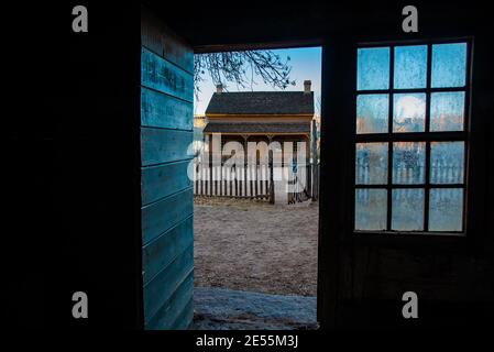 A upscale pioneer home viewed through a doorway across the street.  The people are gone, but the history remains. Stock Photo