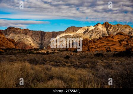 Majestic white rock cliffs contrasted with blue sky and clouds.  This beautiful area is part of Snow Canyon State Park, Utah, USA. Stock Photo