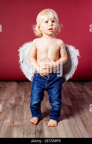 Infant baby with angel wings and jeans Stock Photo