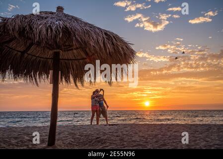 Couple taking selfie photo on the beach at sunset in Puerto Vallarta, Jalisco, Mexico. Stock Photo