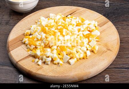 Chopped hard-boiled eggs on a cutting board. Salad ingredients. Stock Photo