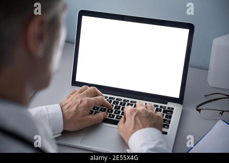 Male doctor using laptop computer with blank white mockup screen technology. Stock Photo