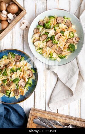 Mushroom pasta salad with steamed broccoli and baked chicken meat slices for lunch Stock Photo