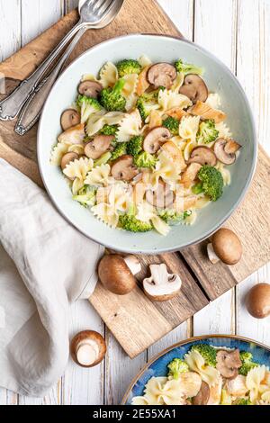 Mushroom pasta salad with steamed broccoli and baked chicken meat slices for lunch Stock Photo