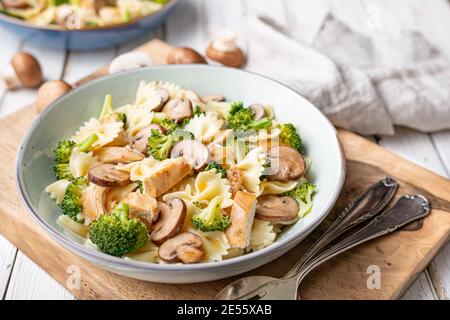 Mushroom pasta salad with steamed broccoli and baked chicken meat slices for lunch Stock Photo