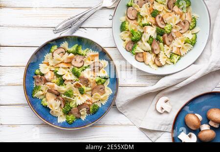 Mushroom pasta salad with steamed broccoli and baked chicken meat slices for lunch Stock Photo