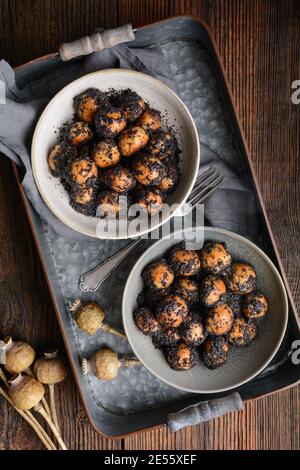 Sweet Slovakian Christmas pastry Opekance also known as Bobalky or Pupaky with poppy seeds on rustic wooden background Stock Photo