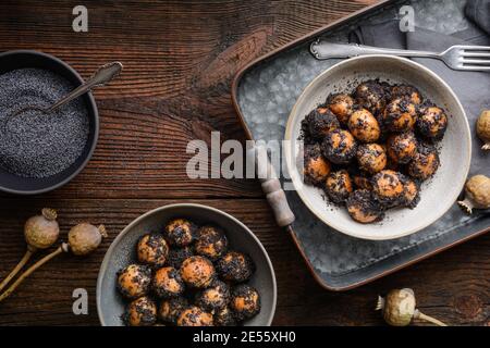 Sweet Slovakian Christmas pastry Opekance also known as Bobalky or Pupaky with poppy seeds on rustic wooden background Stock Photo